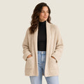 Cárdigan beige de punto grueso con cuello chal y bolsillos